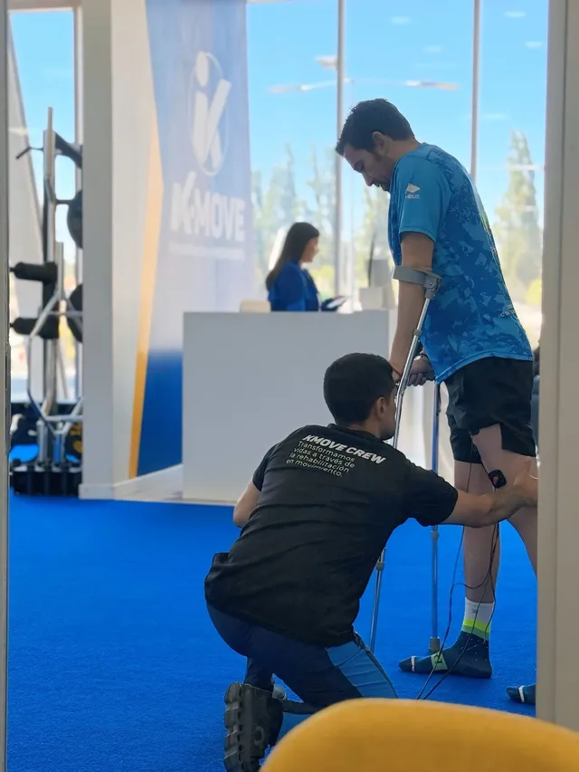Kinesiólogo de KMOVE acompañando a un paciente con muletas