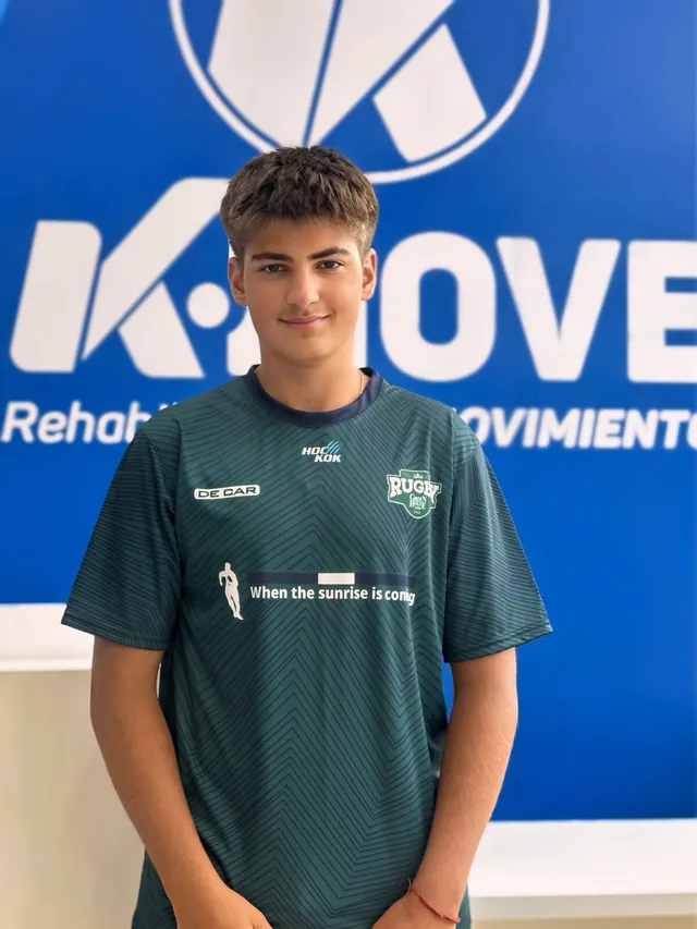 Kmover con camiseta de rugby frente al logo de KMOVE