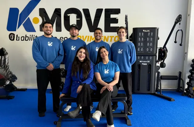 Equipo de kinesiólogos de KMOVE frente al logo del centro