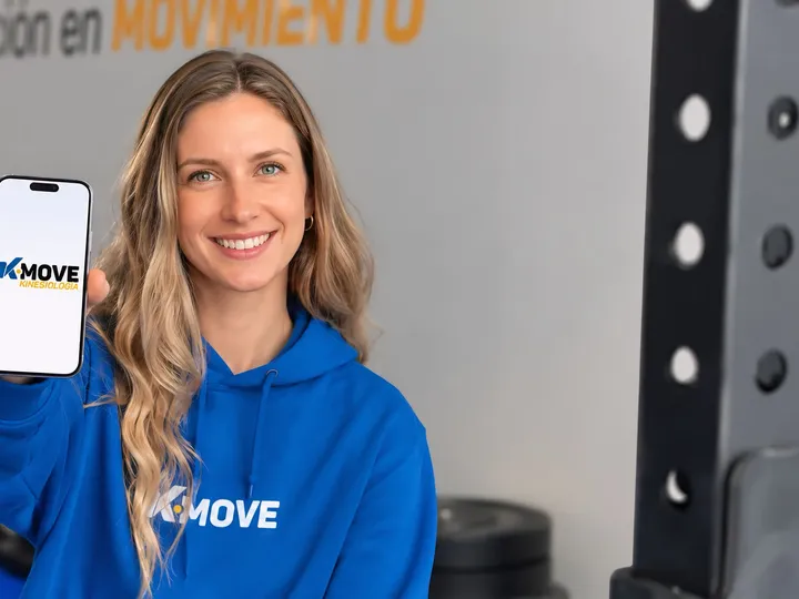 Integrante del equipo KMOVE mostrando el logo de KMOVE en su celular